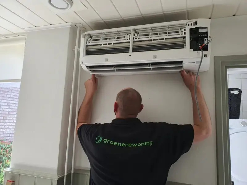 Monteur van Groenere Woning monteert de binnenunit van een airco